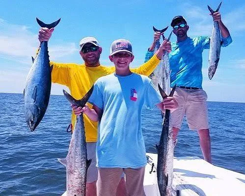 Guests holding their catch during a fishing tour